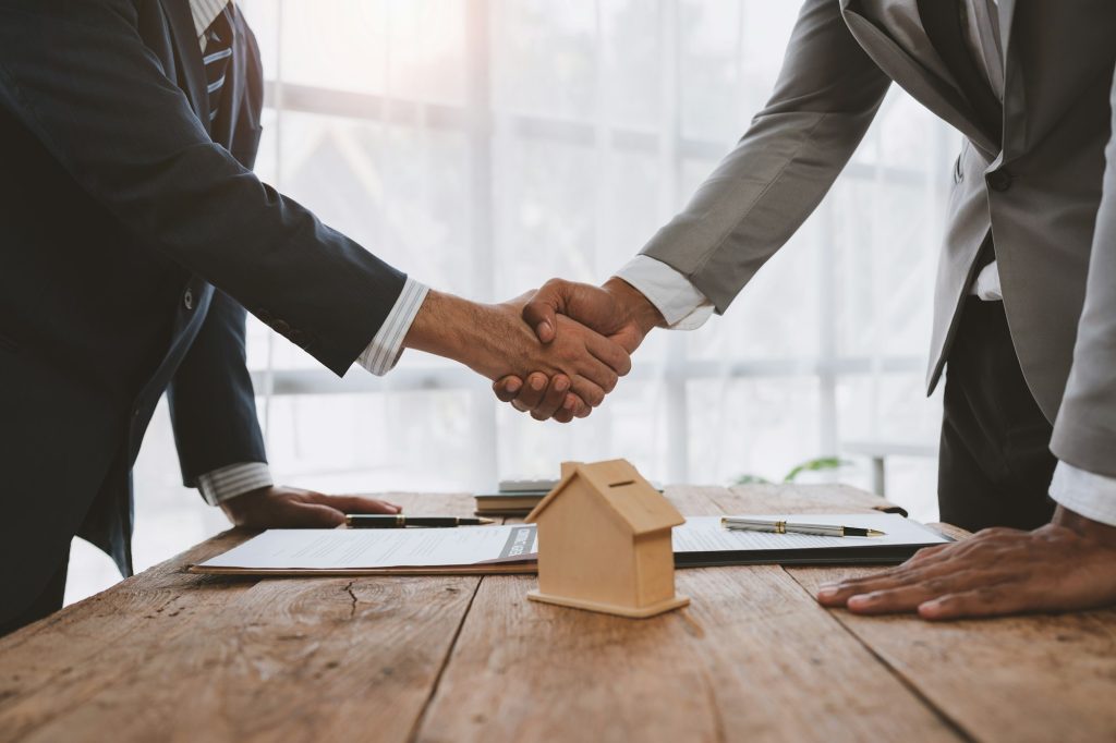 Handshake of real estate brokers with customers or investors, mortgage loan agreements Make a lease-
