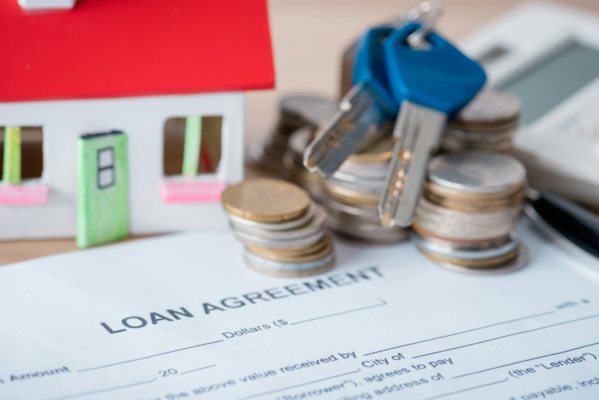 house model, loan agreement, coins and keys on wooden surface house model, loan agreement, coins and keys on wooden surface